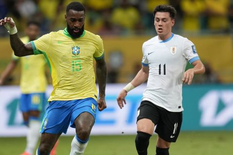 Brazil's Gerson, left, is challenged by Uruguay's Facundo Pellistri during a qualifying soccer match for the FIFA World Cup 2026 at Arena Fonte Nova in Salvador, Brazil, Tuesday, Nov.19, 2024. (AP Photo/Andre Penner)