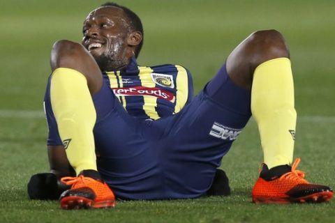 FILE--In this Aug. 31, 2018, file photo Usain Bolt lies on the pitch after taking a shot at goal during a friendly trial soccer match between the Central Coast Mariners and the Central Coast Select in Gosford, Australia. Bolt's bid to become a professional soccer player in Australia has ended with the Olympic sprinting great failing to agree on a contract with the Mariners. (AP Photo/Steve Christo, File)