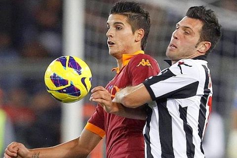 AS Roma's Erik Lamela (L) fights for the ball with Udinese's Maurizio Domizzi during their Italian Serie A soccer match at the Olympic stadium in Rome October 28, 2012.  REUTERS/Giampiero Sposito (ITALY - Tags: SPORT SOCCER)