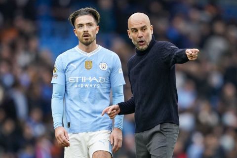 Manchester City's head coach Pep Guardiola, right, speaks with Manchester City's Jack Grealish at the end of the English Premier League soccer match between Manchester City and Arsenal at the Etihad stadium in Manchester, England, Sunday, March 31, 2024. (AP Photo/Dave Thompson)