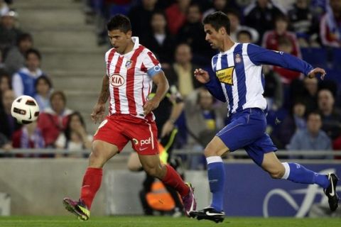 Atletico Madrid's Kun Aguero (L) shoots before scoring a goal against Espanyol's Raul Rodriguez during their Spanish first division soccer match at Cornella-El Prat stadium, near Barcelona, April 17, 2011. REUTERS/Albert Gea (SPAIN - Tags: SPORT SOCCER)