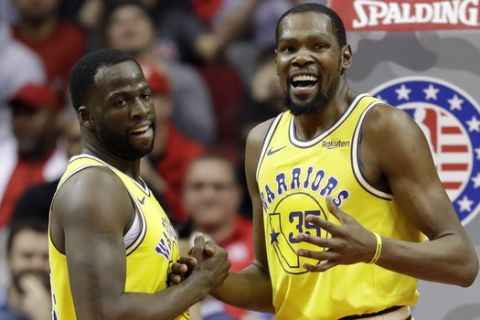 Golden State Warriors' Kevin Durant (35) talks with Draymond Green after a turnover during the second half of an NBA basketball game against the Houston Rockets Thursday, Nov. 15, 2018, in Houston. (AP Photo/David J. Phillip)