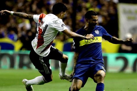 Enzo Perez of River Plate, left, fights for the ball with Edwin Cardona of Boca Juniors during a local tournament soccer match in Buenos Aires, Argentina, Sunday, Sept. 23, 2018. (AP Photo/Natacha Pisarenko)