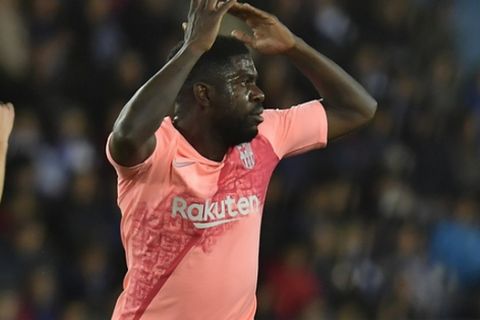 Barcelona defender Samuel Umtiti reacts next to referee Cordero Vega, during a Spanish La Liga soccer match between Deportivo Alaves and FC Barcelona at the Medizorrosa stadium in Vitoria, Spain, Tuesday, April 23, 2019. (AP Photo/Alvaro Barrientos)