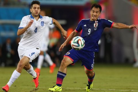 NATAL, BRAZIL - JUNE 19: Shinji Okazaki (R) of Japan shields the ball from Konstantinos Manolas (L)of Greece during the 2014FIFA World Cup Group C match between Japan and Greece at Estadio das Dunas on June 19, 2014 in Natal, Brazil.  (Photo by Michael Steele/Getty Images)