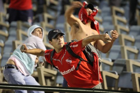 MON01. MONTEVIDEO (URUGUAY), 12/04/2011.- Hinchas de Independiente de Argentina lanzan piedras a los de Peñarol de Uruguay hoy, martes 12 de abril de 2011, en el previo al partido de la fase de grupos de la Copa Libertadores de América que les enfrenta en el estadio Centenario de Montevideo (Uruguay). EFE/Iván Franco