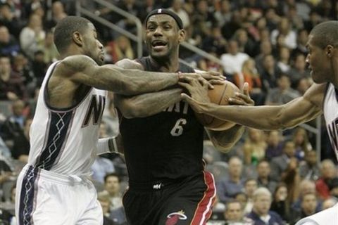 Miami Heat's LeBron James (6), fights off New Jersey Nets'  Terrence Williams, left, and Derrick Favors,right, in the third quarter during an NBA basketball game at the Prudential Center in Newark , N.J., Sunday, Oct. 31, 2010. The Heat defeated the Nets 101-78. (AP Photo/Rich Schultz)