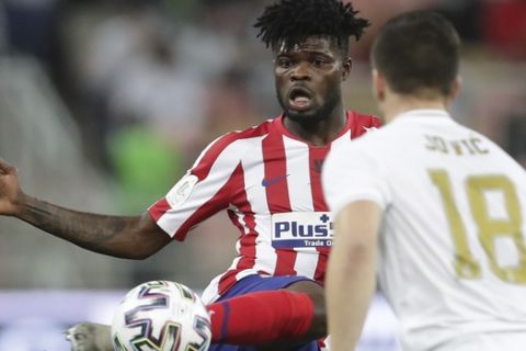 Atletico Madrid's Thomas Partey kicks the ball past Real Madrid's Luka Jovic during the Spanish Super Cup Final soccer match between Real Madrid and Atletico Madrid at King Abdullah stadium in Jiddah, Saudi Arabia, Sunday, Jan. 12, 2020. (AP Photo/Hassan Ammar)