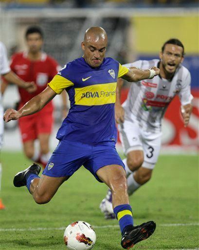 Argentina's Boca Juniors' Santiago Silva, left, kicks the ball beside Venezuela's Zamora's Jaime Andres Bustamante during their Copa Libertadores soccer match in Barinas, Venezula, Tuesday, Feb. 14, 2012.(AP Photo/Fernando Llano)