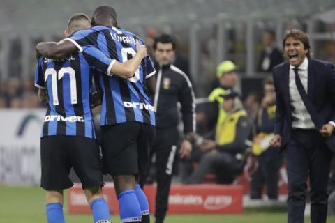 Inter Milan's Romelu Lukaku, right, celebrates his goal with Inter Milan's Marcelo Brozovic during a Serie A soccer match between AC Milan and Inter Milan, at the San Siro stadium in Milan, Italy, Saturday, Sept.21, 2019. At right is Inter Milan's head coach Antonio Conte. (AP Photo/Luca Bruno)