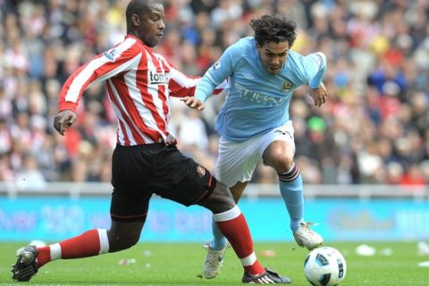 Sunderland's English defender Titus Bramble (L) fights for the ball with Manchester City's Argentinian forward Carlos Tevez during the English Premiership football match at The Stadium Of Light, in Sunderland, northeast England, on August 29, 2010. AFP PHOTO/ANDREW YATES FOR EDITORIAL USE ONLY Additional licence required for any commercial/promotional use or use on TV or internet (except identical online version of newspaper) of Premier League/Football League photos. Tel DataCo +44 207 2981656. Do not alter/modify photo. (Photo credit should read ANDREW YATES/AFP/Getty Images)