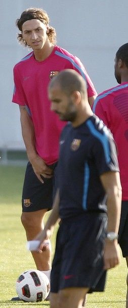 Barcelona's coach Pep Guardiola (front) and player Zlatan Ibrahimovic (back, facing camera) take part in a training session at Joan Gamper training camp, near Barcelona, August 27, 2010. Barca is still locked in negotiations with AC Milan to sell Swedish striker Ibrahimovic before the end of the transfer window. REUTERS/Albert Gea (SPAIN - Tags: SPORT SOCCER)