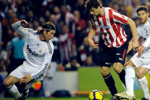 BI16 BILBAO 16/01/2010.- El delantero del AthlÈtic de Bilbao Fernando Llorente (c) trata de llevarse el balÛn entre dos jugadores del Real Madrid, el defensa Sergio Ramos (i) y el centrocampista Xabi Alonso, en una acciÛn del partido que ha enfrentado esta tarde a ambos conjuntos en el estadio de San MamÈs, duelo correspondiente a la decimoctava jornada del Campeonato Nacional de Liga en Primera DivisiÛn. EFE/MIGUEL TOA