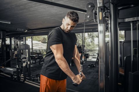 A man doing triceps pushdown exercise at the gym