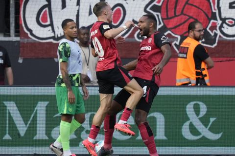 Leverkusen's Florian Wirtz, left, and Jonathan Tah celebrate after a goal during the German Bundesliga soccer match between Bayer Leverkusen and VfL Wolfsburg at the BayArena in Leverkusen, Germany, Sunday, Sept. 22, 2024. (AP Photo/Martin Meissner)