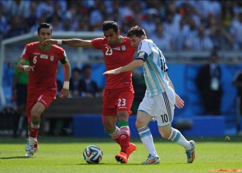 BELO HORIZONTE, BRAZIL - JUNE 21: Lionel Messi of Argentina in action with Mehrdad Pooladi of Iran during the 2014 FIFA World Cup Brazil Group F match between Argentina and Iran at Estadio Mineirao on June 21, 2014 in Belo Horizonte, Brazil.  (Photo by Chris Brunskill Ltd/Getty Images)