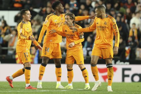 Real Madrid's Luka Modric, center, celebrates with teammates after scoring his side's first goal against Valencia during a Spanish La Liga soccer match at Mestalla stadium in Valencia, Spain, Friday, Jan. 3, 2025. (AP Photo/Alberto Saiz)