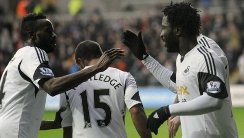 Swansea City's Wilfried Bony (R) celebrates scoring a goal against Manchester City with Roland Lamah during their English Premier League soccer match at the Liberty Stadium in Swansea, Wales, January 1, 2014. REUTERS/Rebecca Naden (BRITAIN - Tags: SPORT SOCCER) NO USE WITH UNAUTHORIZED AUDIO, VIDEO, DATA, FIXTURE LISTS, CLUB/LEAGUE LOGOS OR "LIVE" SERVICES. ONLINE IN-MATCH USE LIMITED TO 45 IMAGES, NO VIDEO EMULATION. NO USE IN BETTING, GAMES OR SINGLE CLUB/LEAGUE/PLAYER PUBLICATIONS. FOR EDITORIAL USE ONLY. NOT FOR SALE FOR MARKETING OR ADVERTISING CAMPAIGNS