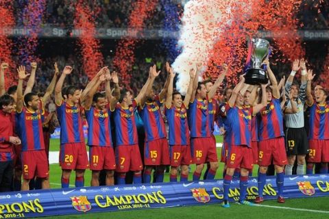 Barcelona players raise the Spanish league title trophy as they celebrate after their Spanish League football match between FC Barcelona and Deportivo on May 15, 2011 at the Nou Camp stadium in Barcelona. AFP PHOTO/ LLUIS GENE (Photo credit should read LLUIS GENE/AFP/Getty Images)