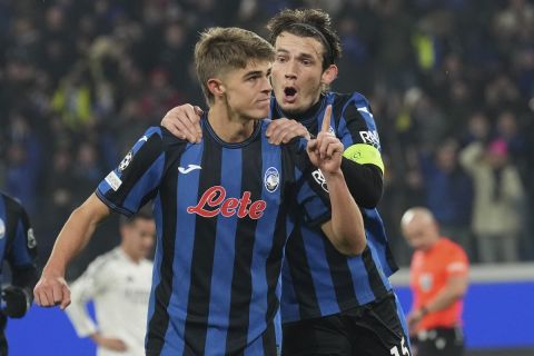 Atalanta's Charles De Ketelaere, left, celebrates with his teammate Atalanta's Marten de Roon after he scored his side's first goal during the Champions League opening phase soccer match between Atalanta and Real Madrid at the Bergamo's stadium, in Bergamo, Italy, Tuesday, Dec. 10, 2024. (AP Photo/Antonio Calanni)