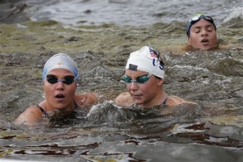 Italy's Martina Grimaldi, left, and U.S.'s Eva Fabian, center, at the finish line during the 10km marathon swimming International Olympic test event at Hyde Park's Serpentine lake in London, Saturday, Aug. 13, 2011. Hyde Park will host the London 2012 Olympic 10km Marathon Swimming competition next year. (AP Photo/Sang Tan)