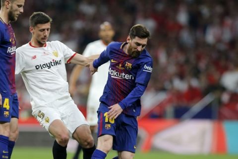 Barcelona's Lionel Messi, right, duels for the ball with Sevilla's Clement Lenglet during the Copa del Rey final soccer match between Barcelona and Sevilla at the Wanda Metropolitano stadium in Madrid, Spain, Saturday, April 21, 2018. (AP Photo/Paul White)