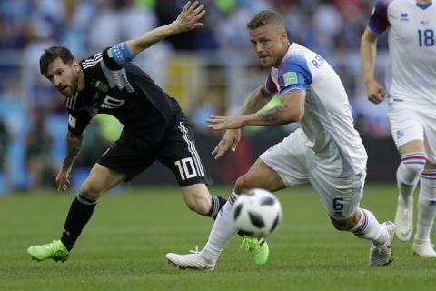 Argentina's Lionel Messi, left, and Iceland's Ragnar Sigurdsson challenge for the ball during the group D match between Argentina and Iceland at the 2018 soccer World Cup in the Spartak Stadium in Moscow, Russia, Saturday, June 16, 2018. (AP Photo/Matthias Schrader)