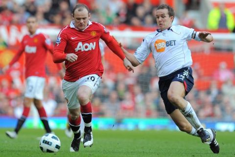 Manchester United's English striker Wayne Rooney (L) vies with Bolton Wanderers' English striker Kevin Davies (R) during the English Premier League football match between Manchester United and Bolton Wanderers at Old Trafford in Manchester, north-west England on March 19, 2011. AFP PHOTO/ANDREW YATESRESTRICTED TO EDITORIAL USE Additional licence required for any commercial/promotional use or use on TV or internet (except identical online version of newspaper) of Premier League/Football League photos. Tel DataCo +44 207 2981656. Do not alter/modify photo (Photo credit should read ANDREW YATES/AFP/Getty Images)