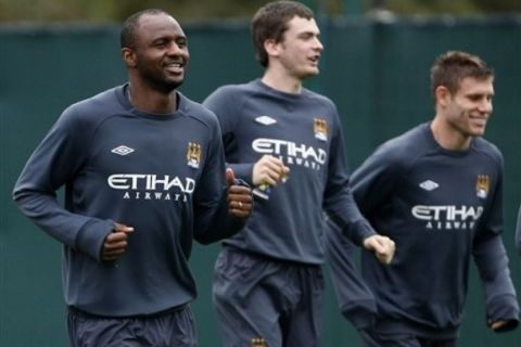 Manchester City's Patrick Vieira, left, warms up with team mates Adam Johnson and James Milner, right, during a training session at Manchester City's Carrington training ground, Manchester, England, Wednesday Sept. 29, 2010. Manchester City will play Juventus in their Europa League Group A soccer match Thursday. (AP Photo/Tim Hales)