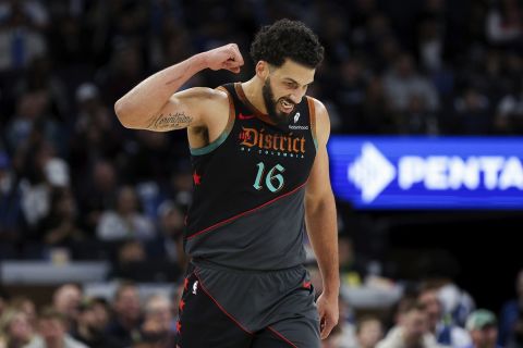 Washington Wizards forward Anthony Gill (16) reacts to guard Jordan Poole's 3-point basket against the Minnesota Timberwolves during the first half of an NBA basketball game Tuesday, April 9, 2024, in Minneapolis. (AP Photo/Matt Krohn)