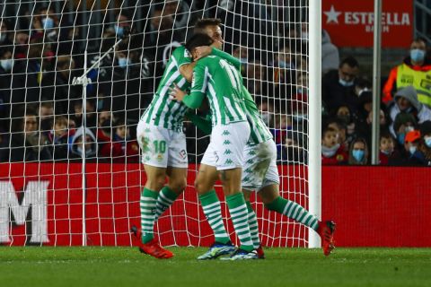 Betis players celebrate after teammate Juanmi scored the opening goal during the Spanish La Liga soccer match between Barcelona and Real Betis at the Camp Nou stadium, in Barcelona, Spain, Saturday, Dec. 4, 2021. (AP Photo/Joan Monfort)