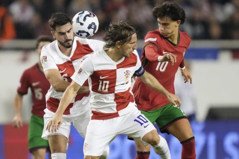 Portugal's Joao Felix, right, challenges for the ball with Croatia's Luka Modric during the UEFA Nations League soccer match between Croatia and Portugal at Poljud stadium in Split, Croatia, Monday, Nov. 18, 2024. (AP Photo/Darko Bandic)