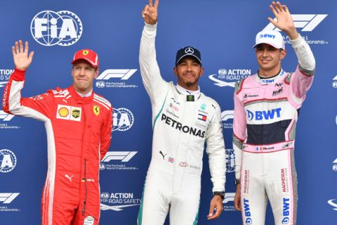 Mercedes driver Lewis Hamilton of Britain, center, who won pole position, poses with Ferrari driver Sebastian Vettel of Germany, left, who placed second and Force India driver Esteban Ocon of France, who placed third at the qualifying session of the Belgian Formula One Grand Prix in Spa-Francorchamps, Belgium, Saturday, Aug. 25, 2018. The Belgian Formula One Grand Prix will take place on Sunday, Aug. 26, 2018. (AP Photo/Geert Vanden Wijngaert)