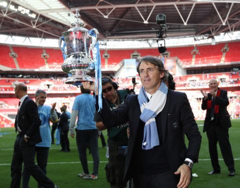 Manchester City's manager  Roberto Mancini celebrates with the FA Cup after beating Stoke 1-0 during the FA Cup final football match between Manchester City and Stoke City at Wembley Stadium in London, on May 14, 2011. AFP PHOTO / ADRIAN DENNIS
NOT FOR MARKETING OR ADVERTISING USE/RESTRICTED TO EDITORIAL USE (Photo credit should read ADRIAN DENNIS/AFP/Getty Images)