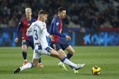 Barcelona's Robert Lewandowski, right, and Leganes' Jorge Saenz challenge for the ball during the Spanish La Liga soccer match between Barcelona and Leganes at the Lluis Companys Olympic Stadium in Barcelona, Spain, Sunday, Dec. 15, 2024. (AP Photo/Joan Monfort)