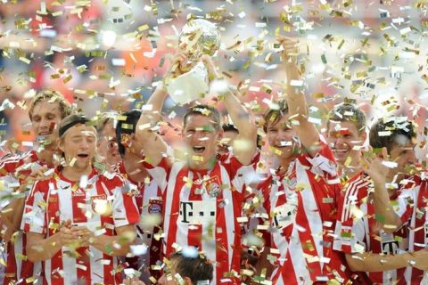 Bayern Munich's midfielder Bastian Schweinsteiger (C) and his teammates celebrate with the trophy after winning the German football Super Cup final between German first division Bundesliga football teams FC Bayern Munich and Schalke 04 in the stadium in Augsburg, southern Germany, August 7, 2010. Munich defeated Schalke 2-0.   AFP PHOTO / CHRISTOF STACHE (Photo credit should read CHRISTOF STACHE/AFP/Getty Images)(Photo Credit should Read /AFP/Getty Images)