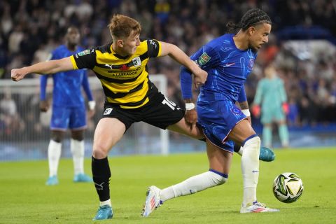 Barrow's Ged Garner, left, challenges for the ball with Chelsea's Malo Gusto during the English League Cup third round soccer match between Chelsea and Barrow at Stamford Bridge stadium in London, Tuesday, Sept. 24, 2024. (AP Photo/Kirsty Wigglesworth)