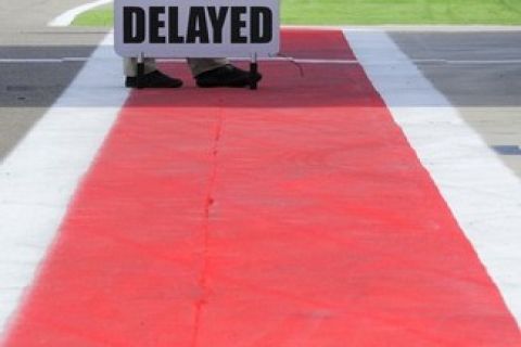 An official holds a sign informing that the MotoGP second practice of the Aragon Grand Prix is delayed due to an electrical problem at Motorland's racetrack in Alcaniz, on September 16, 2011.  AFP PHOTO / JOSE JORDAN (Photo credit should read JOSE JORDAN/AFP/Getty Images)