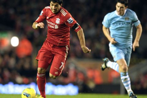 Liverpool's Uruguayan forward Luis Suarez (L) runs with the ball during the English Premier League football match between Liverpool and Manchester City at Anfield in Liverpool, north-west England, on November 27, 2011. AFP PHOTO/ PAUL ELLIS.  RESTRICTED TO EDITORIAL USE. No use with unauthorized audio, video, data, fixture lists, club/league logos or live services. Online in-match use limited to 45 images, no video emulation. No use in betting, games or single club/league/player publications. (Photo credit should read PAUL ELLIS/AFP/Getty Images)