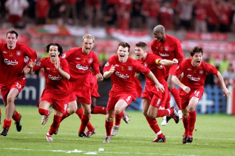 Liverpool players run to goalkeeper Jerzy Dudek to celebrate after AC Milan's Andriy Shevchenko misses his penalty.