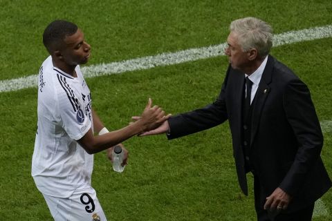 Real Madrid's head coach Carlo Ancelotti, right, congratulates Real Madrid's Kylian Mbappe as he is substituted by Real Madrid's Brahim Diaz during the UEFA Super Cup Final soccer match between Real Madrid and Atalanta at the Narodowy stadium in Warsaw, Poland, Wednesday, Aug. 14, 2024. (AP Photo/Darko Vojinovic)