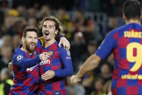 Barcelona's Lionel Messi, left, celebrates after scoring his side's second goal with Antoine Griezmann, centre and Luis Suarez during a Champions League soccer match Group F between Barcelona and Dortmund at the Camp Nou stadium in Barcelona, Spain, Wednesday, Nov. 27, 2019. (AP Photo/Joan Monfort)