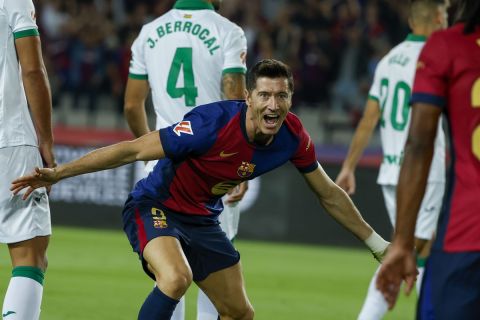 Barcelona's Robert Lewandowski, center, celebrates with Barcelona's Jules Kounde, front, after scoring the opening goal during a Spanish La Liga soccer match between Barcelona and Getafe at the Olympic stadium in Barcelona, Spain, Wednesday, Sept. 25, 2024. (AP Photo/Joan Monfort)