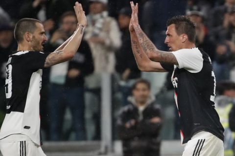 Juventus' Mario Mandzukic, right, celebrates with his teammate Juventus' Leonardo Bonucci after scoring the opening goal during the Serie A soccer match between Juventus and Atalanta at the Allianz stadium, in Turin, Italy, Sunday, May 19, 2019. (AP Photo/Antonio Calanni)