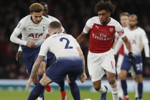 Arsenal's Alex Iwobi, right, challenges for the ball with Tottenham's Kieran Trippier during the English League Cup quarter final soccer match between Arsenal and Tottenham Hotspur at the Emirates stadium in London, Wednesday, Dec. 19, 2018. (AP Photo/Frank Augstein)