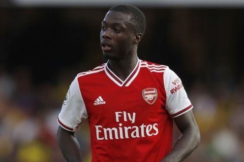 Arsenal's Nicolas Pepe watches is teammates play during their English Premier League soccer match between Watford and Arsenal at the Vicarage Road stadium in Watford near London, Sunday, Sept., 15, 2019. (AP Photo/Alastair Grant)