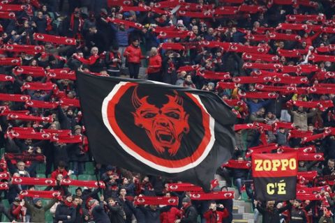 AC Milan supporters hold their scarves prior to the start of the Serie A soccer match between AC Milan and Sassuolo at the San Siro stadium, in Milan, Italy, Sunday, Dec. 15, 2019. (AP Photo/Antonio Calanni)