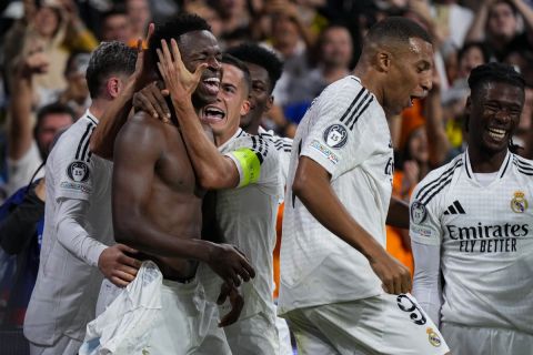 Real Madrid's Vinicius Junior, left, celebrates with teammates after scoring his side's fourth goal during the Champions League opening phase soccer match between Real Madrid and Borussia Dortmund at the Santiago Bernabeu stadium in Madrid, Tuesday, Oct. 22, 2024. Real Madrid won 5-2. (AP Photo/Manu Fernandez)