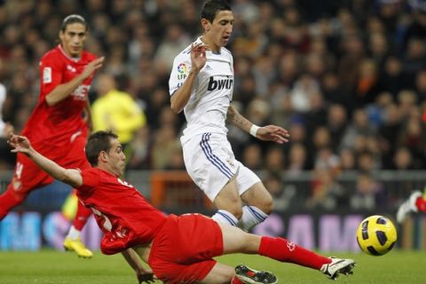 MADRID, SPAIN - DECEMBER 19: Angel di Maria of Real Madrid duels for the ball with Fernando Navarro of Sevilla during the La Liga match between Real Madrid and Sevilla at Estadio Santiago Bernabeu on December 19, 2010 in Madrid, Spain. (Photo by Angel Martinez/Getty Images)