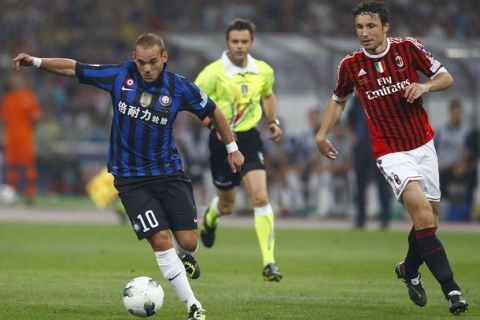 Inter Milan's Wesley Sneijder (L) dribbles next to AC Milan's Mark Van Bommel (R) during their Italian Super Cup soccer match at the National Olympic Stadium, also known as the Bird's Nest, in Beijing, August 6, 2011. REUTERS/Petar Kujundzic (CHINA - Tags: SPORT SOCCER)